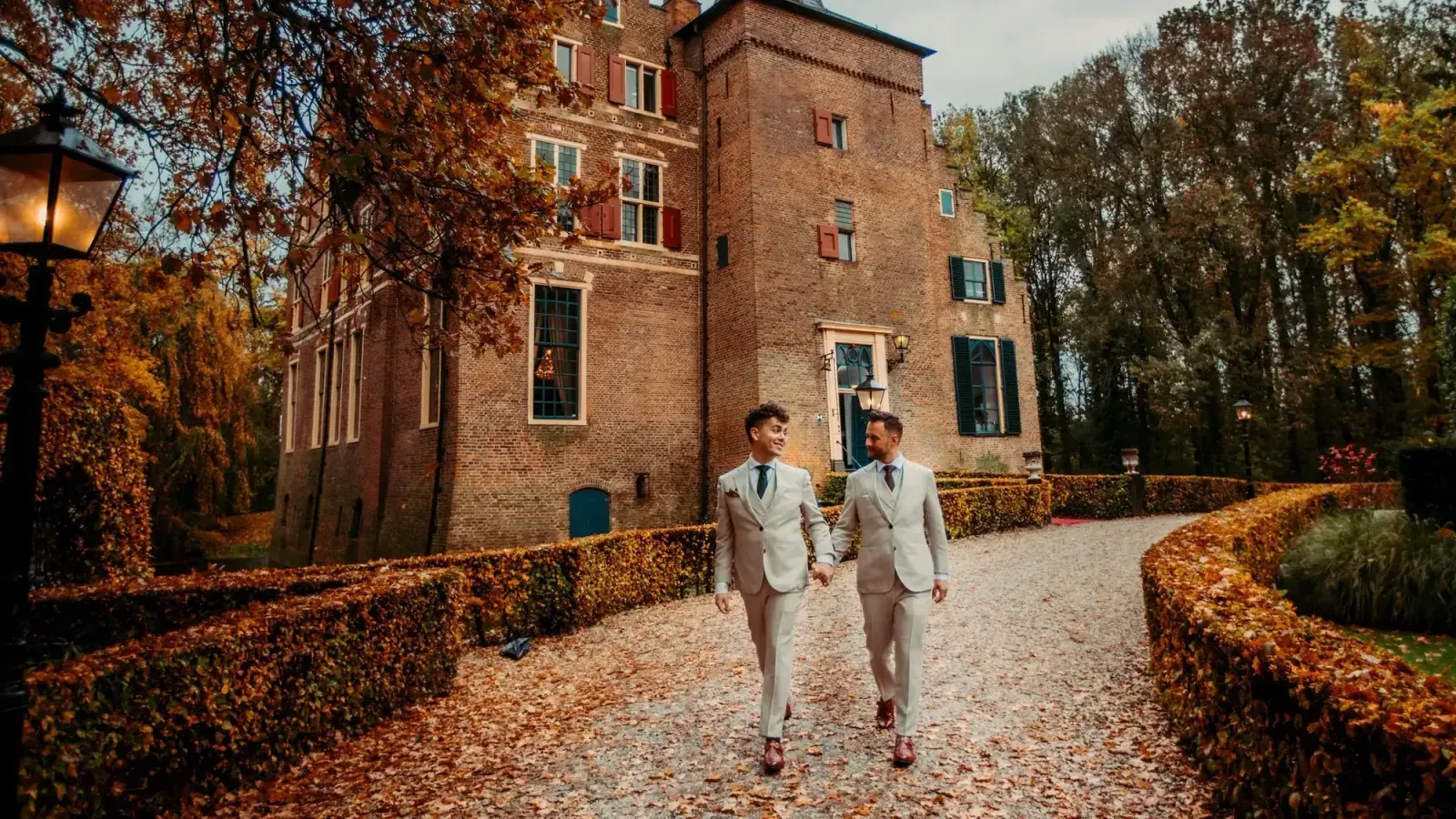 Een bruidspaar loopt over het pad naar Kasteel Wijenburg
