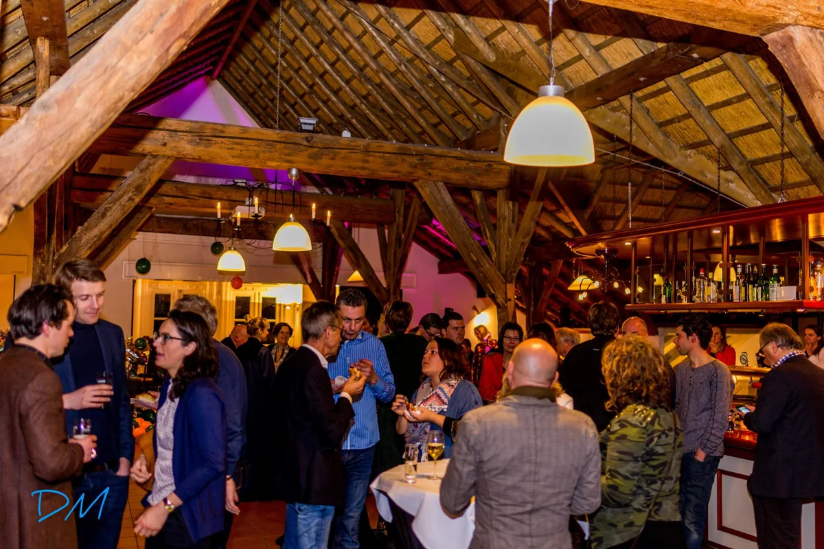 Gasten met een drankje in het Theehuis, onder de houten kapconstructie