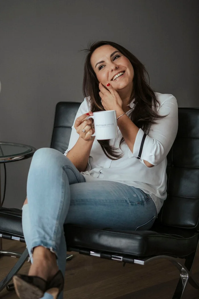 Kim Vankan, eigenaresse van Boutique Office, met een kop koffie in een van haar vergaderruimtes