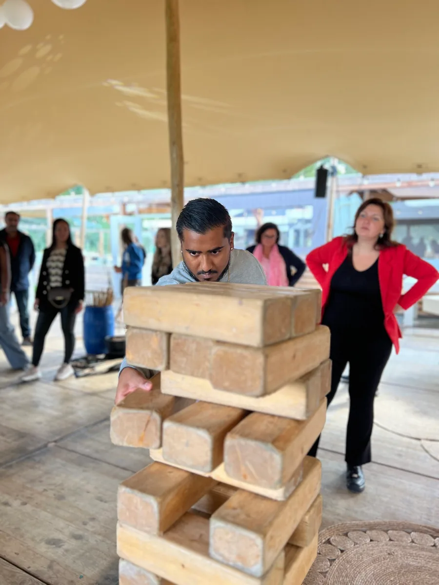 Gasten spelen een groot Jenga-spel op de vlonder aan het water