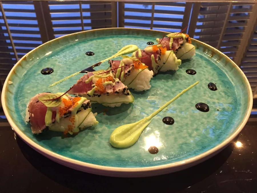 Een bord met sushi en bites in het midden van de tafel