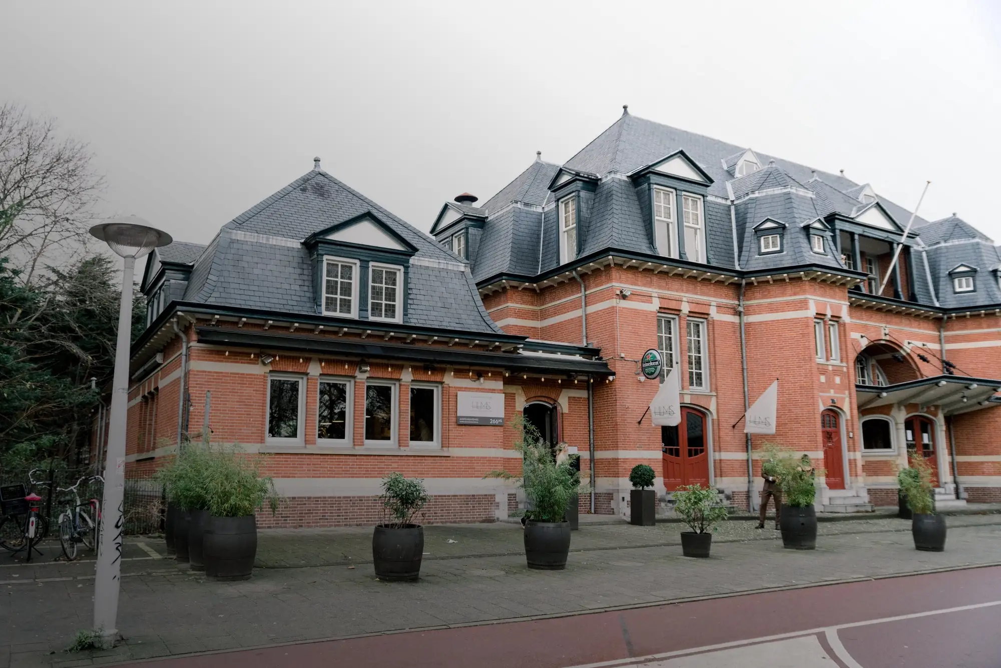 De rode bakstenen gevel van het voormalige Haarlemmermeerstation aan de Amstelveenseweg in Amsterdam