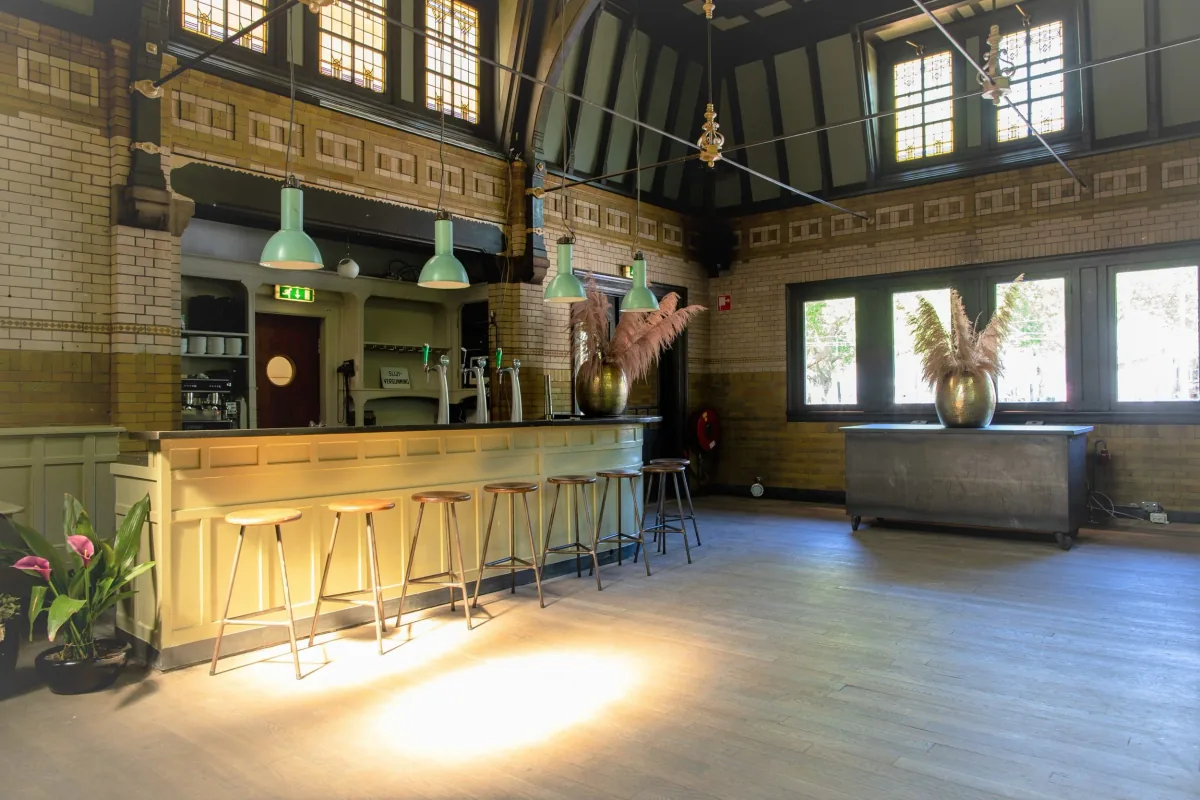 De lange mintgroene bar in de Derde Klasse Wachtruimte, met krukken en de lege zaal erachter