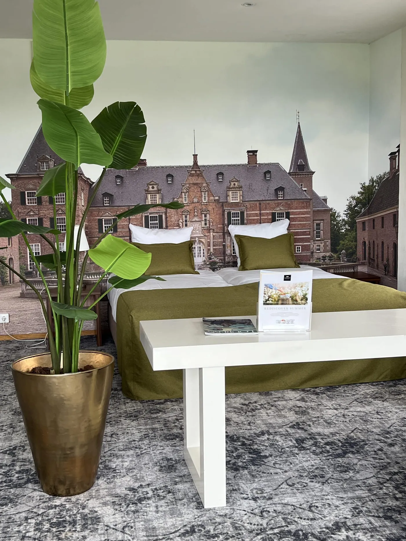 Een bruidspaar zit met twee kinderen in een lichte zaal met bloemen en droogbloemen