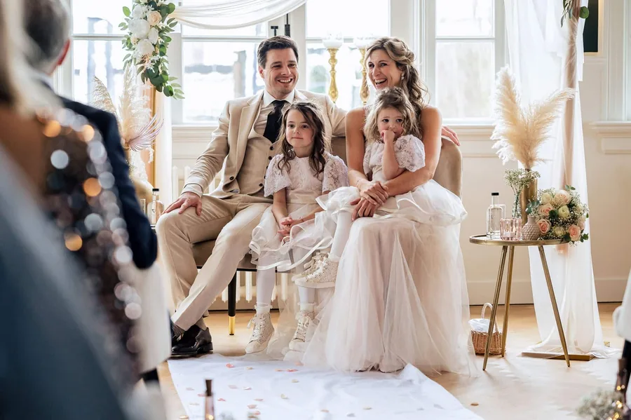 Een feestelijk gedekte zaal met kaarsen, bloemen en kroonluchters